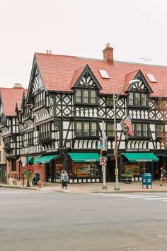 an old black and white building with green awnings