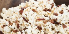 a wooden bowl filled with popcorn on top of a table