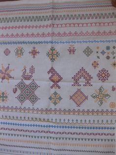 a close up of a cross stitch pattern on a table cloth with an embroidered design