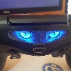 a close up of a video game controller with glowing blue eyes on it's face