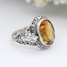 A stunning, chunky antique or true vintage sterling silver and Citrine quartz statement ring, with an elaborate openwork bezel and shoulders. A really lovely thing, with a great amount of detail. Stamped for silver to the inside. In really nice, antique condition, with a bit of wear to the edges of the stone, but no major signs of age or use. Approximate Measurements:  Stone - 1.4cm by 1.1cm UK Size - P US Size - 7 1/2 Weight - 4.3 grams -------------------- All boxes in the photographs are for display purposes only, unless stated otherwise. Please be aware there will be marks and wear commensurate with age. Please see all of the photos. Feel free to contact me with any questions. Yellow Quartz, Antique Ring, Citrine Ring, Silver Enamel, Antique Rings, True Vintage, Statement Ring, Rings Statement, Vintage Sterling Silver