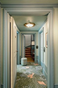 an empty hallway with blue walls and carpet