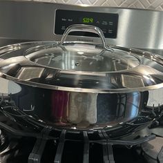 a stainless steel pot sitting on top of an oven burner with the lid open