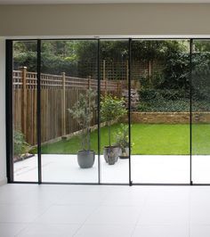 an empty room with sliding glass doors leading to a garden