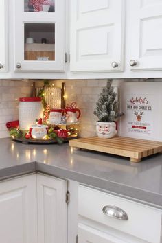 a kitchen counter with white cabinets and christmas decorations