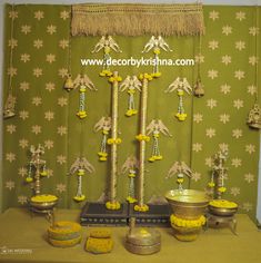 a table topped with vases filled with yellow flowers and decorations next to a green wall