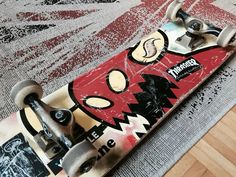 a skateboard that has been placed on the floor with some graffiti painted on it