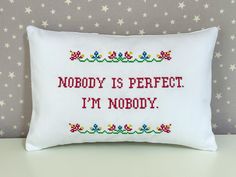 a cross stitch pillow that says nobody is perfect i'm nobody