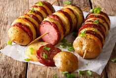 several sausages and potatoes on skewers with tomatoes