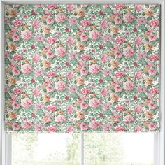 a pink and green floral roman blind in front of a window