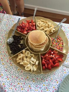 a plate with pancakes, strawberries, chocolate chips and sprinkles on it