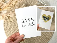 someone holding up two cards that say save the date and heart on them with an image of a cat