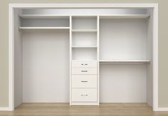 an empty white closet with shelves and drawers on the wall, in front of a wooden floor