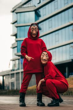 two people in red outfits with masks on their faces