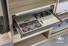 an open drawer in a cabinet with several different buttons and ties on the bottom shelf