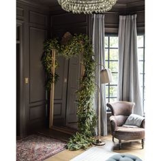 a living room filled with furniture and a chandelier hanging from the ceiling next to a window