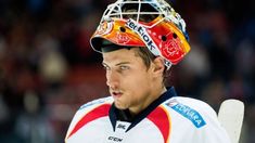 a man wearing a helmet and holding a hockey stick