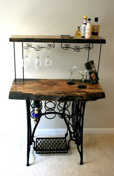 an old sewing table with wine glasses on it