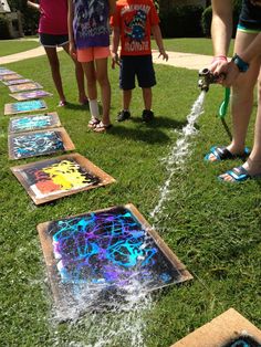 children are playing with water hoses on the grass