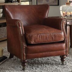 a brown leather chair sitting on top of a rug