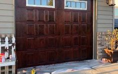 a brown garage door sitting on the side of a house