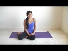 a woman is sitting on a yoga mat