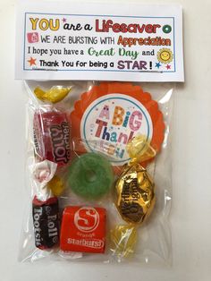 an assortment of candy and candies in a plastic bag on a white surface with a sign that says you are a lifesaver appreciation