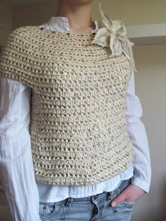 a woman wearing a white top with a crocheted bow on the neck and sleeves