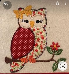 an appliqued owl is sitting on a branch with red flowers and leaves