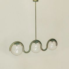 three glass balls hanging from a brass chandelier in a living room or dining room