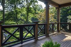 a wooden deck with railings and potted plants on the other side of it