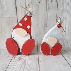 two wooden toy cars with red and white hats on them, sitting next to each other