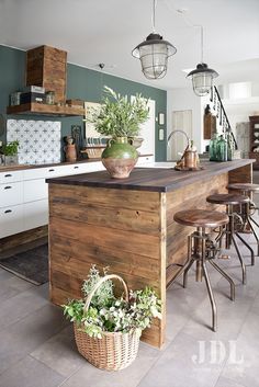 a kitchen with an island made out of wooden planks and metal barstools