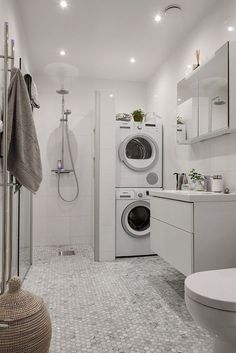 a washer and dryer in a bathroom with white tiles on the flooring