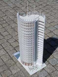 a tall white building sitting on top of a brick floor next to a parking lot