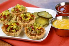 small appetizers with pickles and sauces on a plate