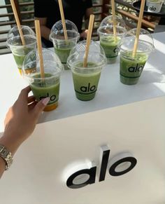 a table topped with cups filled with green liquid