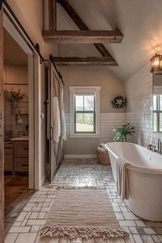 a bathroom with a tub, rug and windows