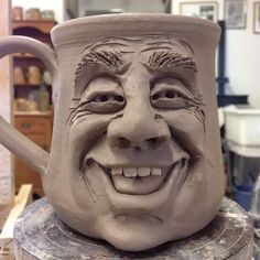 a clay mug with a smiling face on it