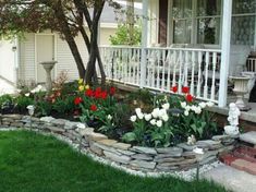 the flowers are blooming in the garden by the front porch and steps to the house