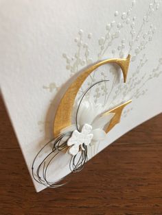 a white and gold greeting card with flowers on the front, featuring a crescent design