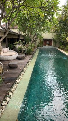 an outdoor swimming pool surrounded by greenery