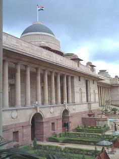 the building has many pillars and arches on it's sides, along with some plants