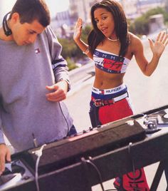 a man standing next to a woman in front of a dj's set up