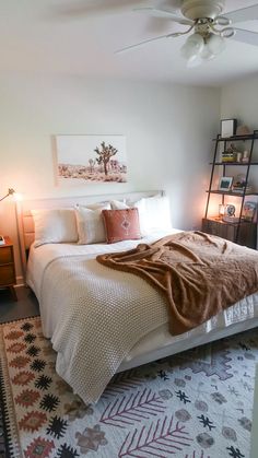 a bedroom with a bed, rug and ceiling fan