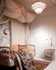 a bedroom with a canopy bed and chandelier hanging from it's ceiling