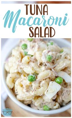 a bowl filled with macaroni salad on top of a wooden table next to a fork