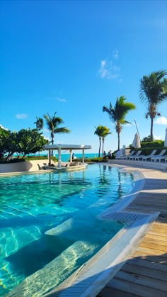 an empty swimming pool surrounded by palm trees