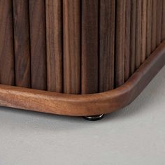 a close up of a wooden shelf on a gray wall with wood slats in the background