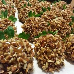 several pieces of food with nuts and leaves on it sitting on a table next to each other